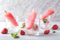 Glasses with delicious strawberry popsicles on wooden table Royalty Free Stock Photo