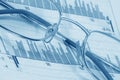 Glasses on diagrams (blue toned) Royalty Free Stock Photo