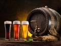 Glasses of different types of chilled beer, beer cask and wheat on wooden table Royalty Free Stock Photo