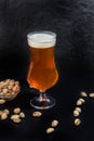 Glasses with different types of craft beer on a wooden bar. In glasses and bottles. Nuts and crackers on the table. On a Royalty Free Stock Photo