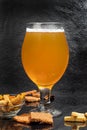 Glasses with different types of craft beer on a wooden bar. In glasses and bottles. Nuts and crackers on the table. On a Royalty Free Stock Photo