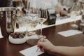 Glasses with different types of wine by human hand writing notes about wine glasses Royalty Free Stock Photo