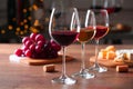 Glasses with different wines and appetizers on wooden table against blurred background