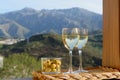 Glasses of dry white wine and spanish tapas olives in bowl with mountains peaks on background in sunny day Royalty Free Stock Photo