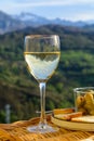 Glasses of dry white wine and spanish tapas olives in bowl with mountains peaks on background in sunny day Royalty Free Stock Photo