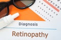 Glasses, eye drops and eye test chart is around inscription Diagnosis Retinopathy. Concept photo for causes, diagnosis, treatment