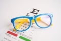 Glasses on eye testing exam chart to check eyesight accuracy of reading