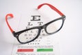 Glasses on eye testing exam chart to check eyesight accuracy of reading Royalty Free Stock Photo