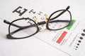 Glasses on eye testing exam chart to check eyesight accuracy of reading Royalty Free Stock Photo