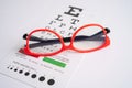 Glasses on eye testing exam chart to check eyesight accuracy of reading Royalty Free Stock Photo