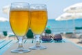2 glasses filled with ice-cold beer standing on a table at the beach Royalty Free Stock Photo