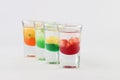 Glasses filled with vodka, each topped with passion fruit, strawberry, apple, and mango Royalty Free Stock Photo