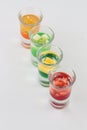 Glasses filled with vodka, each topped with passion fruit, strawberry, apple, and mango Royalty Free Stock Photo