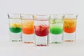 Glasses filled with vodka, each topped with passion fruit, strawberry, apple, and mango Royalty Free Stock Photo