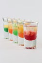 Glasses filled with vodka, each topped with passion fruit, strawberry, apple, and mango Royalty Free Stock Photo