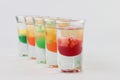 Glasses filled with vodka, each topped with passion fruit, strawberry, apple, and mango Royalty Free Stock Photo