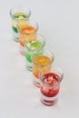 Glasses filled with vodka, each topped with passion fruit, strawberry, apple, and mango Royalty Free Stock Photo