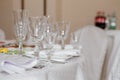 Glasses, flowers, fork, knife, napkin folded in a pyramid, served for dinner in restaurant with cozy interior. Wedding decorations Royalty Free Stock Photo