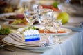 Glasses, forks, knives, napkins and decorative flower on a table served for dinner in cozy restaurant Royalty Free Stock Photo