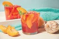 Glasses with fresh homemade peach sweet iced tea or cocktail, lemonade with mint. Refreshing cold drink. Summer party
