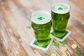 Glasses of green beer with shamrock and gold coins