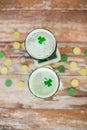Glasses of green beer with shamrock from top