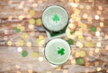 Glasses of green beer with shamrock from top