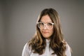 Glasses, hair and portrait of girl nerd in studio on gray background for accessories or fashion. Face, intelligence and