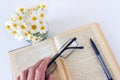 Glasses in hand on an old book open on white table background. Royalty Free Stock Photo