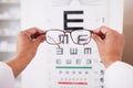 Glasses in hands, optometry and vision, eye care and health with eyesight test and chart, prescription lens and frame Royalty Free Stock Photo