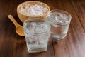 Glasses with ice cubes on wooden background