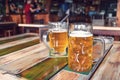 Glasses of light beer on pub background. Pint glass of golden beer with snacks