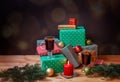 Glasses of mulled wine, colorful gifts, christmas balls, fir branches and burning candle on dark background. Selective focus Royalty Free Stock Photo
