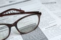 Glasses on newspaper, closeup. Search concept