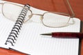 Glasses, notepad with pen