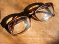 Reading glasses and old book, glasses on aged shabby background