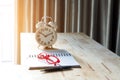 Glasses on Open Notebook with Alarm Clock on Wood Desk