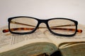 Glasses on the open old book. Retro mood.