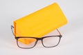 Glasses optical new and orange case pyramid on a grey background