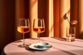 Glasses with orange amber wine on a round pink table, bathed in the caustic light of summer. The minimalist, luxury view. Perfect