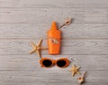 Glasses of orange color and sunscreen on a wooden background. Royalty Free Stock Photo
