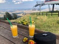 Glasses of orange juice on a table with a chairlift at Tornik, Zlatibor mountain, Serbia Royalty Free Stock Photo