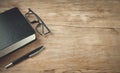 Glasses, pen, book on wooden table Royalty Free Stock Photo