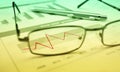 Glasses and pen on financial chart and graph, success concept, g Royalty Free Stock Photo