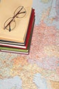 Glasses on pile of books on map Royalty Free Stock Photo