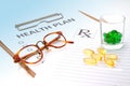 Glasses and pill capsules on health plan notes Royalty Free Stock Photo
