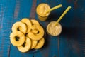 Glasses of pineapple fruit juice and a plate with pieces of pineapple fruit over old wooden background Royalty Free Stock Photo