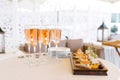 Glasses of pink champagne stand on the buffet table next to a plate of appetizers