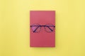 Glasses placed on red book, On yellow background