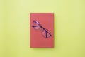 Glasses placed on red book, On yellow background